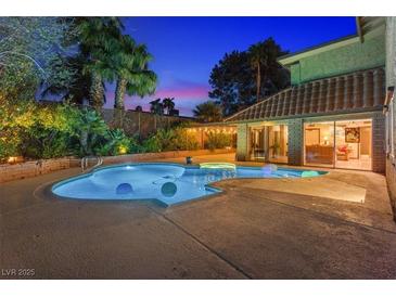 Backyard pool with landscaping, patio, and sliding glass doors leading inside at 4360 Flandes St, Las Vegas, NV 89121