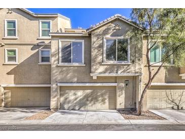 Contemporary townhouse with a two-car garage and stucco facade on a sunny day at 4516 Townwall St, Las Vegas, NV 89115
