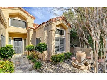 Inviting home exterior boasts beautiful stone landscaping, a water feature, and a charming, covered entryway at 5010 Longboat Cir, Las Vegas, NV 89113