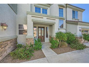 Inviting front entrance with a rustic wood door and beautiful stone accents, landscaped for curb appeal at 5337 Polizze Ave, Las Vegas, NV 89141