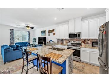 Bright open-concept kitchen with stainless steel appliances and granite countertops, connecting to the living room at 7364 N Decatur Blvd # 4, Las Vegas, NV 89131