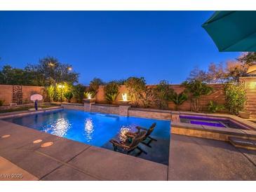Inviting pool featuring in-pool seating, a spa, and fire features nestled within a landscaped backyard for ultimate relaxation at 8429 Brackenfield Ave, Las Vegas, NV 89178