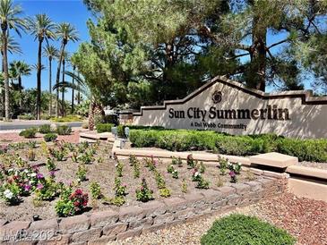Sun City Summerlin community sign amid lush landscaping, palm trees, and clear blue sky at 8552 Desert Holly Dr, Las Vegas, NV 89134