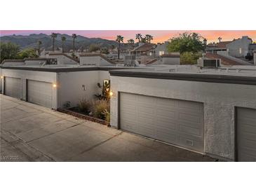 Row of garages at dusk with desert landscaping at this home with mountain views at 2146 High Dunes Ln, Laughlin, NV 89029