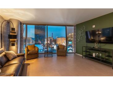 Modern living room with a leather sofa and expansive windows overlooking the Las Vegas skyline at 3722 Las Vegas Blvd # 1908, Las Vegas, NV 89158