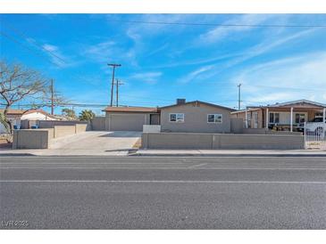 Charming single-story home with a two car garage and well-maintained front yard under a blue sky at 4629 Alta Dr, Las Vegas, NV 89107