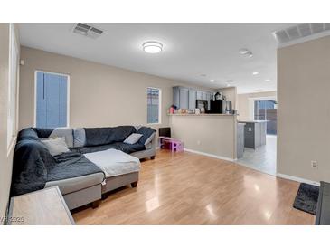 Open-concept living room boasts wood floors and neutral paint scheme for flexible design options at 6461 Karlsen Ct, Las Vegas, NV 89122
