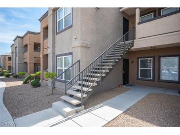 Apartment building featuring a modern design, exterior staircase, and well-maintained landscaping at 6650 W Warm Springs Rd # 1079, Las Vegas, NV 89118