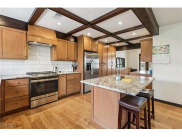 Well-lit kitchen features stainless steel appliances, a tiled backsplash, and hardwood flooring at 6712 Kittery Dr, Las Vegas, NV 89107