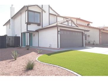 Inviting two-story home featuring a manicured lawn, a two-car garage, and a charming aqua-colored front door at 8101 Spur Ct, Las Vegas, NV 89145