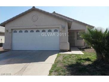 Single story home featuring desert landscaping, a two-car garage, and covered entryway at 2242 Glastonbury Thorn St, North Las Vegas, NV 89032