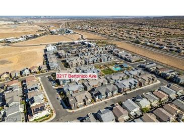 An aerial view of the community of new homes with shared pool, desert landscaping and stunning city views at 3217 Bertonico Ave, Henderson, NV 89044