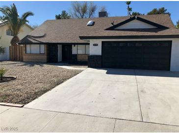 Charming single-story home featuring a gravel yard, black garage door, and unique stone accents at 3409 El Cortez Ave, Las Vegas, NV 89102