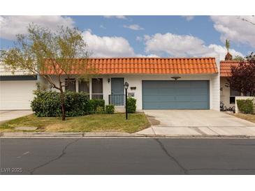 Charming single story home with orange tile roof, blue garage door, and well maintained front yard at 3871 Sinclair St, Las Vegas, NV 89121