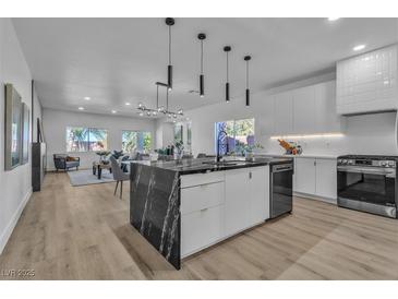 Open-concept kitchen with marble island, stainless steel appliances, and ample natural light at 4434 Verdiccio Ave, Las Vegas, NV 89141