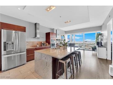 Modern kitchen featuring stainless steel appliances and a large island with counter seating and a beautiful city view at 4471 Dean Martin Dr # 2204, Las Vegas, NV 89103