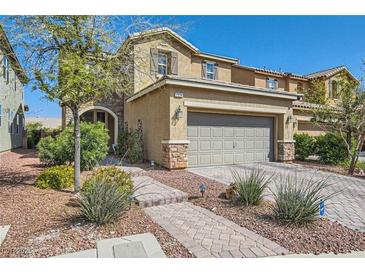 Inviting two-story home featuring a well-manicured lawn, stone accents, and a spacious two-car garage at 7154 Brighton Village St, Las Vegas, NV 89166