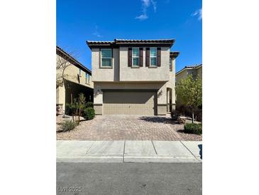 Two-story home with neutral stucco, brown accents, and a brick driveway at 9136 Cocowoods Pl, Las Vegas, NV 89148