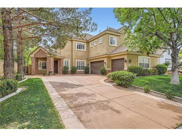 Charming two-story home featuring a brick-accented entrance, mature trees, and a well-manicured lawn at 9733 Camden Hills Ave, Las Vegas, NV 89145