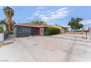 Charming single-story home with a well-maintained front yard and a vibrant red front door at 1408 E Carson Ave, Las Vegas, NV 89101