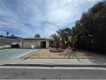 Charming single-story home featuring a desert landscape, mature palm trees, and a covered entryway at 2501 Capistrano Ave, Las Vegas, NV 89121