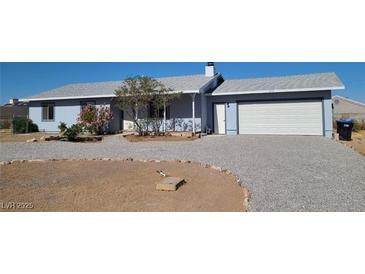 Single story home with blue siding, gravel driveway, and well-maintained front yard at 436 Emden St, Henderson, NV 89015