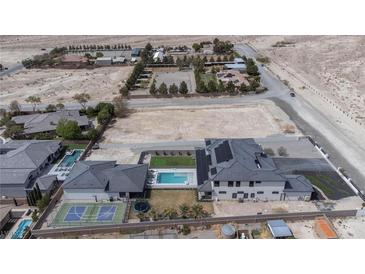 A luxury home features a pool, tennis court, desert landscaping, and ample land for future expansion at 6265 Iron Mountain Rd, Las Vegas, NV 89131