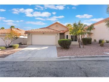 Inviting single-story home showcasing a two-car garage and low-maintenance desert landscaping at 8113 Dolphin Landing Dr, Las Vegas, NV 89128