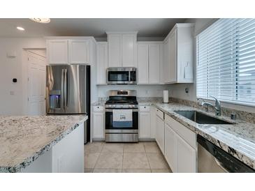 Bright kitchen with white cabinets, stainless steel appliances, and granite countertops at 965 Nevada State Dr # 24201, Henderson, NV 89002