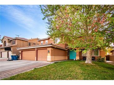 Charming two-story home featuring a well-kept lawn and a welcoming turquoise front door at 1017 Fairbury St, Henderson, NV 89052
