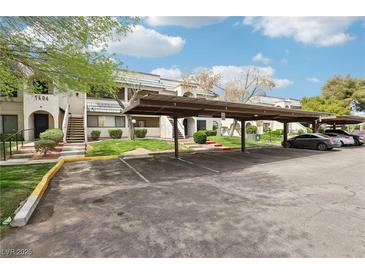 Condos with covered parking, landscaped grounds, and stairs leading to each unit at 1404 Santa Margarita St # D, Las Vegas, NV 89146