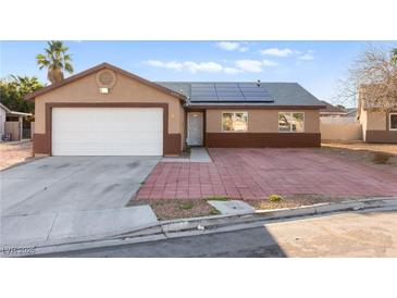 Charming home featuring solar panels, a two-car garage, and a low-maintenance front yard at 2315 Opponents Ridge St, North Las Vegas, NV 89032