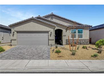 Charming single-story home featuring desert landscaping, a gray exterior, and a spacious two-car garage at 378 Hellebores Ave, North Las Vegas, NV 89084