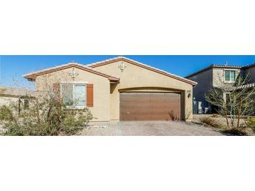 Tan single-story home with a brown two-car garage, landscaped yard, and neutral color palette at 6856 Council Heights Way, Las Vegas, NV 89142