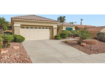 Inviting single-story home featuring a spacious two-car garage, neutral tones, and desert landscaping at 10800 Brinkwood Ave, Las Vegas, NV 89134