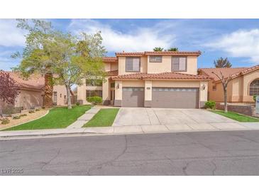 Charming two-story home featuring a red tile roof, three-car garage, and well-manicured front lawn at 1304 Autumn Wind Way, Henderson, NV 89052