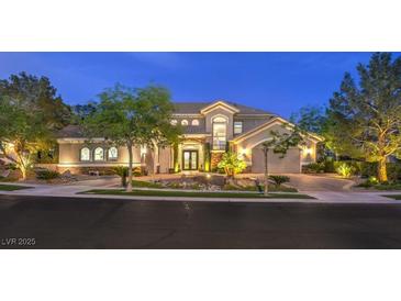 Beautifully landscaped two-story home with a well-manicured lawn and driveway at dusk at 1377 Ruby Sky Ct, Henderson, NV 89052