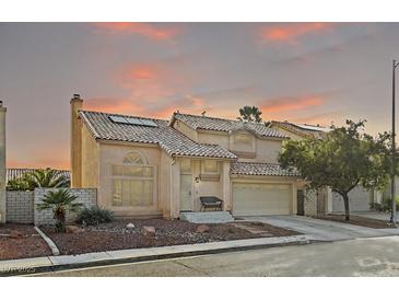 Inviting two-story home with a tile roof, landscaped front yard, and attached two-car garage at 1705 Desert Ridge Ave, North Las Vegas, NV 89031