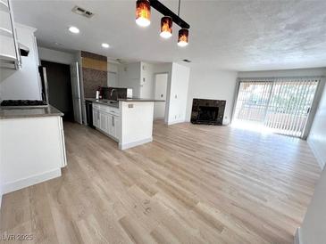 Bright open-concept living room features a fireplace and sliding glass doors at 2200 S Fort Apache Rd # 2123, Las Vegas, NV 89117