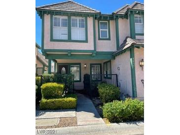 Charming two-story townhouse with pink exterior, green trim, a landscaped front yard, and a welcoming front porch at 4037 Chalfont Ct, Las Vegas, NV 89121