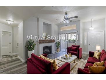Inviting living room with a cozy fireplace, plush seating, and modern ceiling fan at 8805 Jeffreys St # 1018, Las Vegas, NV 89123