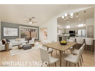 Bright living room featuring a modern sofa, stylish coffee table, and an open dining area adjacent to the kitchen at 10309 Georgetown Pl, Las Vegas, NV 89134