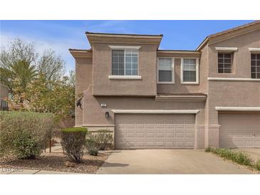 Townhouse with a two car garage, desert landscaping, and neutral toned stucco at 223 Positive Point St, Henderson, NV 89012