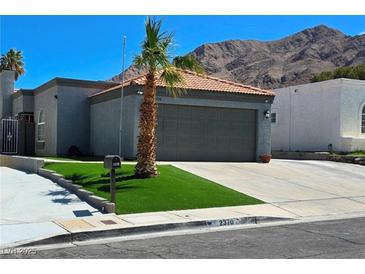 Charming single-story home with mature landscaping, a two-car garage, and a mountain backdrop at 2370 Ray Kanel Dr, Las Vegas, NV 89156
