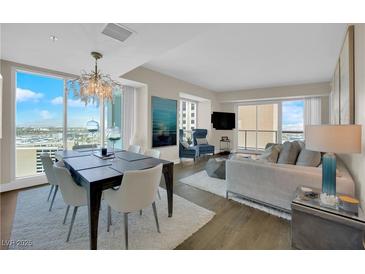 Bright living room featuring hardwood floors, a chandelier, modern furniture, and floor-to-ceiling windows with city views at 2700 Las Vegas Blvd # 1803, Las Vegas, NV 89109