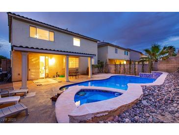 A backyard pool with stone surround is a relaxing oasis with lounge chairs and a covered patio at 3043 Jacaranda Dr, Las Vegas, NV 89117