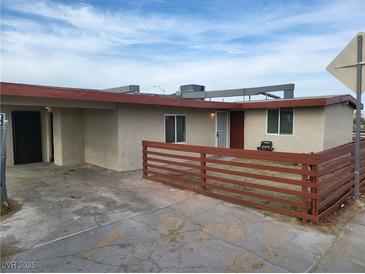 Single story home with a desert landscape, fencing, and covered parking at 310 E Lake Mead Blvd, North Las Vegas, NV 89030