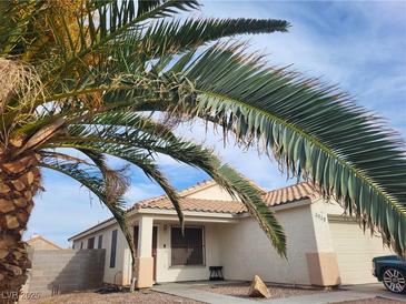 Charming single-story home with desert landscaping, a tile roof, and a lush palm tree at 3616 Rose Canyon Dr, North Las Vegas, NV 89032