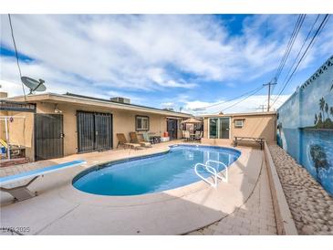 Outdoor pool featuring lounge chairs, diving board and concrete patio area, perfect for outdoor enjoyment at 5093 Sun Valley Dr, Las Vegas, NV 89122