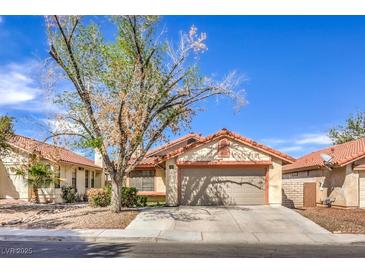 Charming single-story home with a red-tile roof and a well-maintained front yard with mature tree at 620 Macbrey Dr, Las Vegas, NV 89123